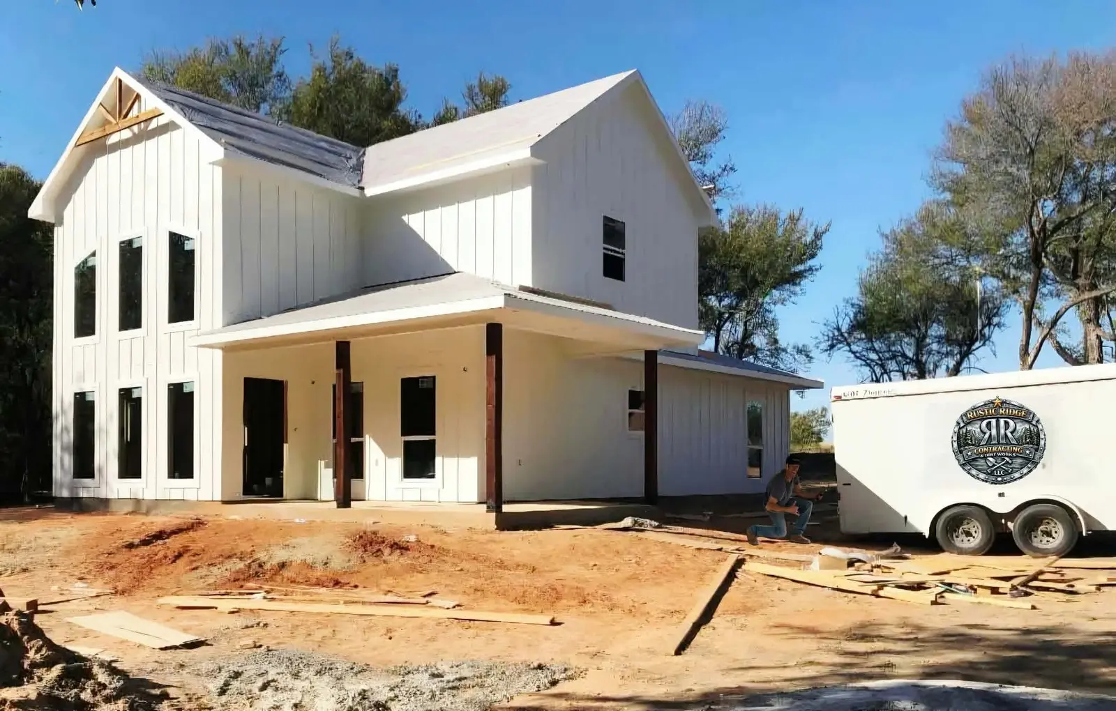 New farmhouse with finished site grading and the Rustic Ridge trailer